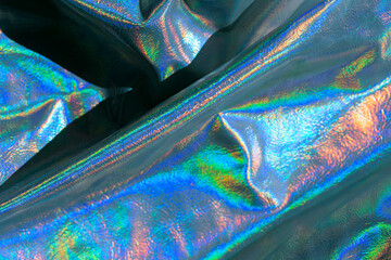  texture with iridescent waves and folds.Abstract trendy holographic background.beautiful metallic shiny fabric.Holographic background. metal holographic wallpaper.