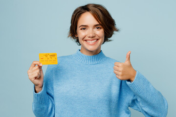 Young cheerful smiling happy fun caucasian woman wearing knitted sweater holding in hand mock up of...