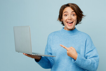 Young caucasian smart IT woman in knitted sweater hold use work point index finger on laptop pc...