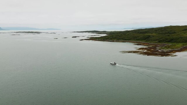 4K Aerial pan around boat leaving Arisaig harbour on Scottish West Coast