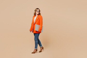 Full body young employee IT business woman corporate lawyer wear classic formal orange suit glasses...