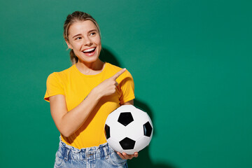 Young woman fan wear basic yellow t-shirt cheer up support football sport team hold in hand soccer...