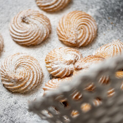 Round cookies sprinkled with powdered sugar on the table. Close-up, top view.