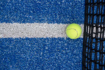 ball on a blue turf court paddle tennis court