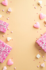 Valentine's Day concept. Top view vertical photo of gift boxes heart shaped marshmallow candles and sprinkles on isolated beige background with copyspace
