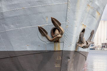 View of a rusted ship's anchor on the anchor hole of a gray ship on the North Sea