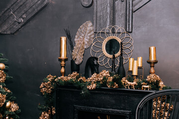 Fireplace with decorations, mirror, candles, statue of horse in black Christmas interior in gold colors