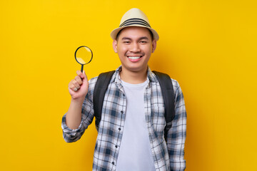 traveler fun explorer tourist Asian man in casual clothes hat with backpack hold magnifier loupe...