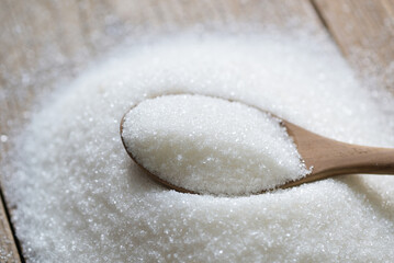 Sugar on spoon and wooden background, white sugar for food and sweets dessert candy heap of sweet sugar crystalline granulated