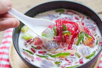 Thai rice flour dessert, Thai dessert -cantaloupe jelly mixed fruit with coconut milk and syrup sweets dessert on bowl, Asian food