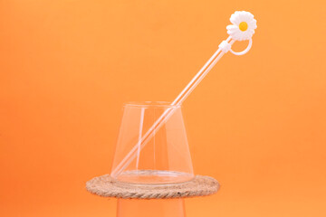 Glass cups and straws on an orange background