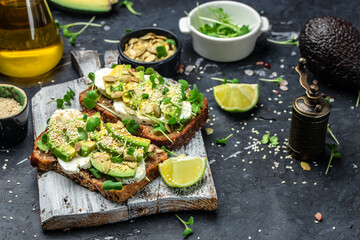 toasts with rye bread, sliced avocado, cheese. Delicious breakfast or snack, Clean eating, dieting, vegan food concept. top view