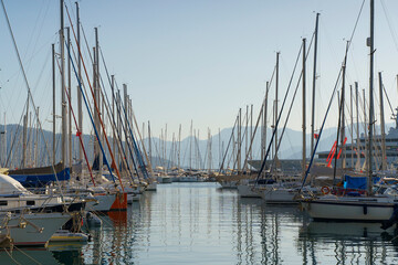 Fototapeta na wymiar Pier with yachts. Many beautiful yachts with masts in the marina. Vacation, travel, luxury concept