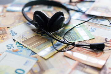 euro banknotes headphones headset. Money and technology still life concept.