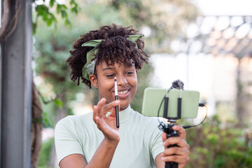 Young blogger artist recording makeup tutorial to share on website or social media.