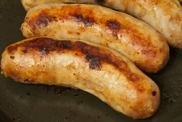 Sausages fried in a frying pan. Closeup