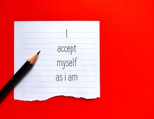 Note on red background with handwritten affirmation message I ACCEPT MYSELF AS I AM, phrases...
