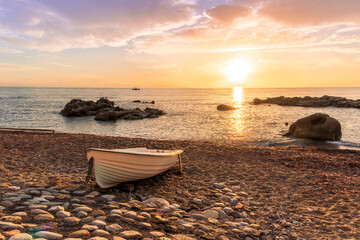 nice old vintage boat on a sea coast with picturesque view on a sunrise in a rocky gulf, landscape of sunset or sunrise bay