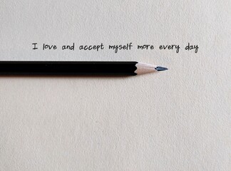 Pencil writing on paper - I accept and love myself more every day - concept of self-love and...