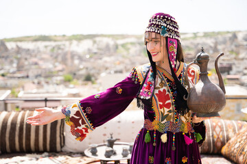 beautiful girl in Turkish national clothes with a teapot in her hands.