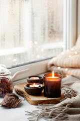 warm cozy window arrangement, winter or autumn concept, candles throw lights