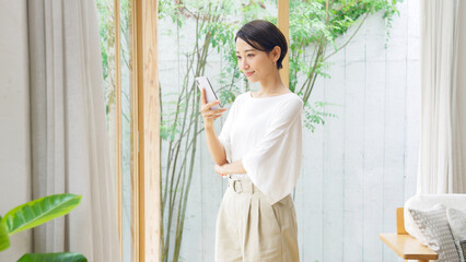 笑顔でスマホを見るミドル女性