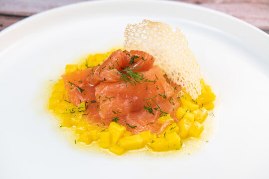 Recipe for salmon gravlax with mango brumoise and white balsamic vinegar dressing. High quality photo