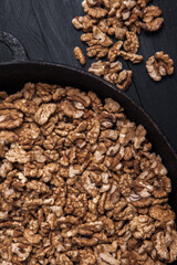 Walnut background. Peeled walnuts on a iron plate on black. walnuts a real super food full of vitamins and vegetable fats
