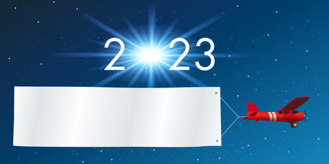 Carte de vœux 2023 montrant un avion rouge tirant une banderole blanche pour souhaiter la bonne année, devant un ciel étoilé.