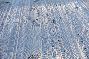 Car tire tracks. Snowy and icy road, dangerous and unsafe. Black ice