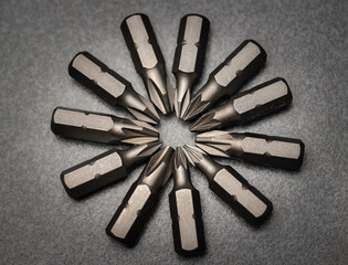 A set of heads for screwdrivers (bits). On a gray background. Close-up. Macro photo, studio shooting.