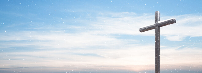 Wooden cross with snow over sky background with falling snow