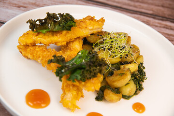 Recipe for Breaded Chicken Tenders and Potatoes with Sesame Kale Chips and Sweet and Sour Sauce. High quality photo