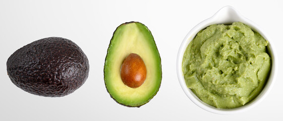 Bowl with guacamole sauce with whole and slice avocado in top view