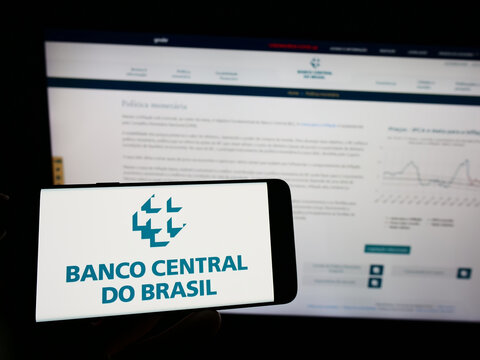 Stuttgart, Germany - 12-02-2022: Person holding mobile phone with logo of central bank Banco Central do Brasil (BCB) on screen in front of web page. Focus on phone display.