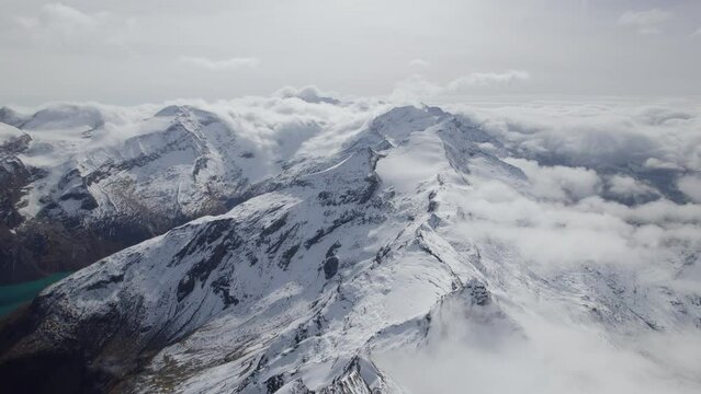 Cinematic aerial panoramic Shot of white snowy mountains during sunlight - Austrian Alps,Europe