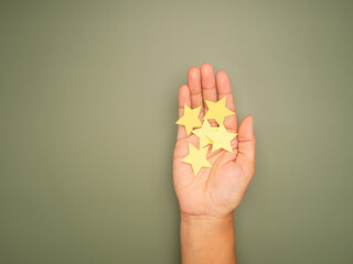 Yellow paper cut in a star shape on the palm with a green background