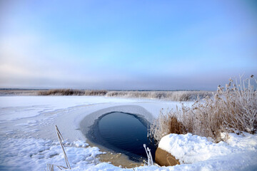 Beautiful winter landscape with lake full of reed covered with hoar frost , selective focus