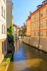 Fototapeta na wymiar Houses by the canal in a cozy touristic European city. Background with selective focus