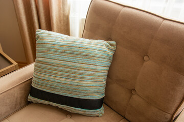 
Blue pillow on brown sofa.