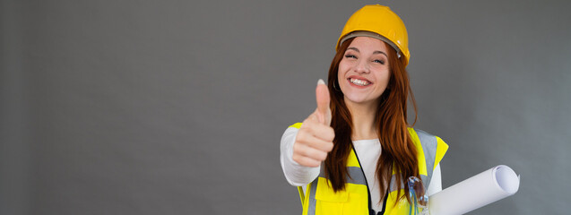Close-up young female architect looking camera gesturing. Woman with positive face smiling with thumb up. Portrait isolated in grey background with copy space, horizontal banner or header.