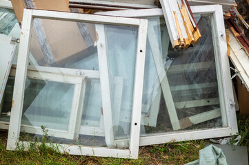the old wooden window frames are dismantled and stacked together. replacement of windows
