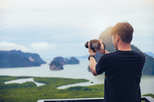 the traveler or photographer standing and taking a photo over the island and river view
