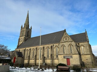 Old stone church with snow on the ground and a blue sky background. Taken in Ramsbottom Lancashire...