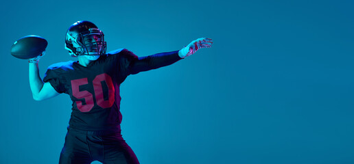 Strong throw. Professional american football player in sports team uniform and protective helmet isolated over blue background in neon light. Power, energy, achievements, skills - Powered by Adobe