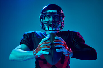 Closeup portrait of american football player in sports team uniform and protective helmet shouting...