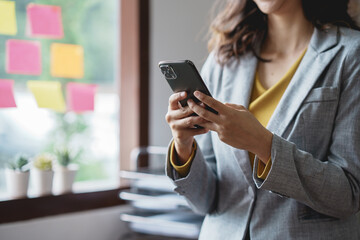 Woman using smartphone working with various applications. Including mobile transactions to send LINE messages and various business information send via social media.