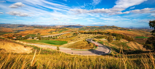 Panoramic view at curved mountain road under the mountain peak.