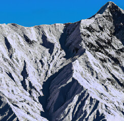 Rocky range of Himalayas mountains against blue sky created using Generative AI technology