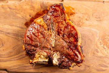 Bistecca di manzo cotta sulla brace al sangue e servita in una braceria su un tagliere di legno 